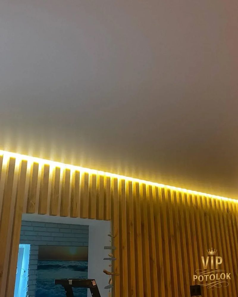 Матова натяжна стеля з прихованою підсвіткою над дверним прорізом і рейками