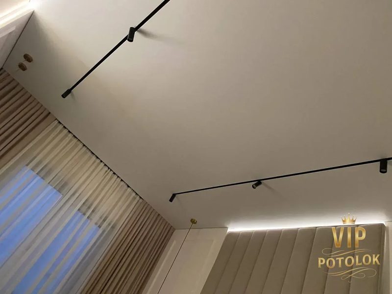 Трекові світильники і теплий парящий контур над узголів’ям ліжка